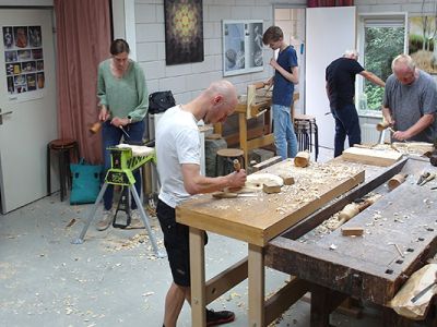 Mensen zijn in werkplaats aan het beeldhouwen in hout